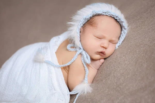 Sover nyfödda flicka i en varsamt blå Stickad mössa. — Stockfoto