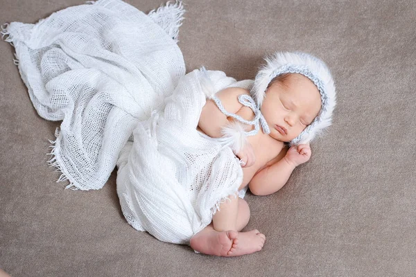 Sleeping newborn baby girl in a gently blue knit hat. — Stock Photo, Image