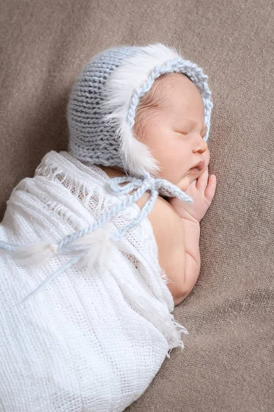 Sover nyfödda flicka i en varsamt blå Stickad mössa. — Stockfoto