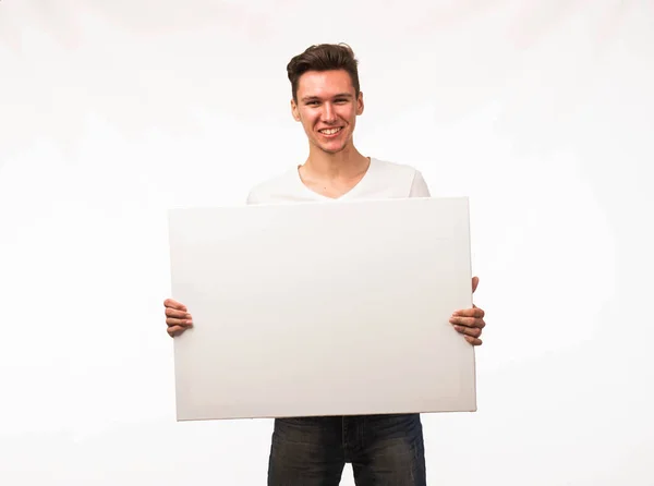 Jovem homem feliz mostrando apresentação, apontando no cartaz . — Fotografia de Stock