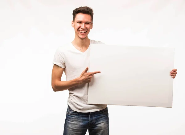 Jovem homem alegre mostrando apresentação, apontando no cartaz . — Fotografia de Stock