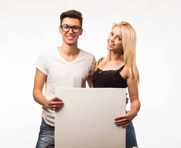 Unga glada par visar presentationen pekar plakat. — Stockfoto