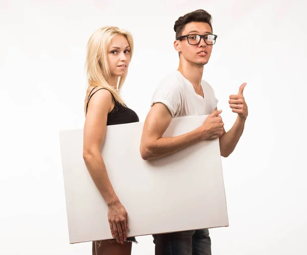 Ung självsäker par visar presentationen pekar plakat. — Stockfoto