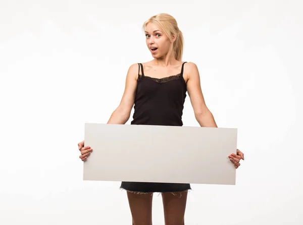 Young surprised woman showing presentation, pointing on placard Stock Image