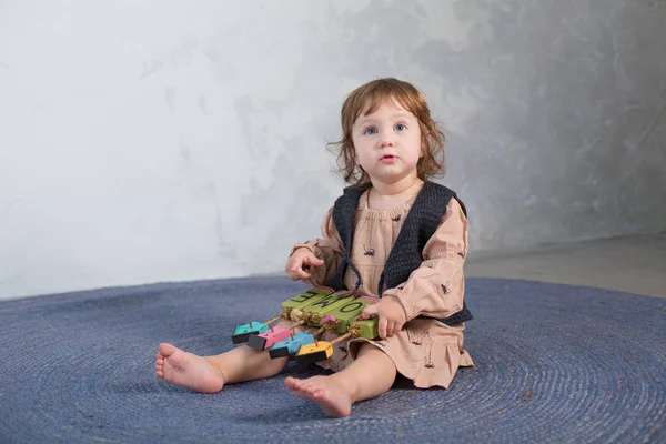 Ευτυχισμένη κοριτσάκι παίζει με το παιχνίδι στο πάτωμα. — Φωτογραφία Αρχείου