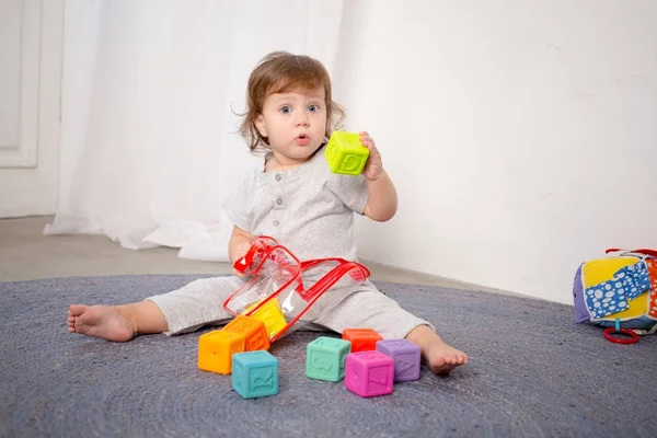 Szczęśliwa dziewczynka bawi się zabawkami na piętrze. — Zdjęcie stockowe