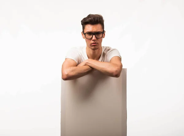 Jovem homem sério mostrando apresentação, apontando no cartaz . — Fotografia de Stock