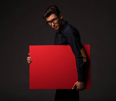 Sunu gösterilen, afiş üzerinde işaret eden genç seksi adam.