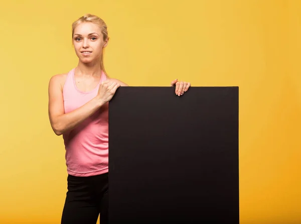 Joven mujer alegre mostrando la presentación, señalando en el cartel — Foto de Stock