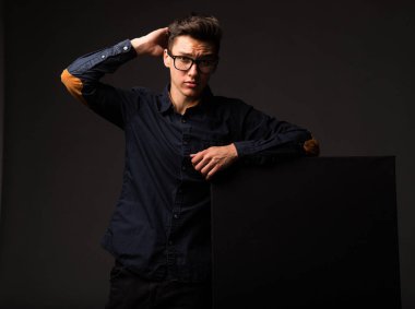 Sunu gösterilen, afiş üzerinde işaret dalgın delikanlı.