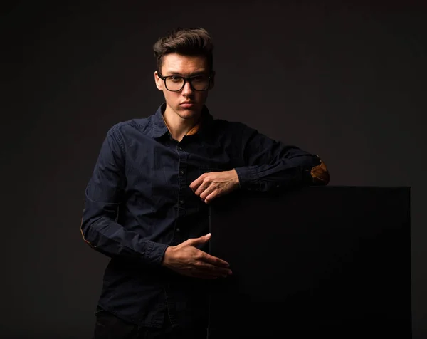 Jovem homem confiante mostrando apresentação, apontando no cartaz . — Fotografia de Stock