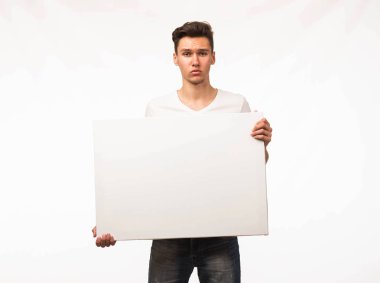 Sunu gösterilen, afiş üzerinde işaret eden genç üzgün adam.