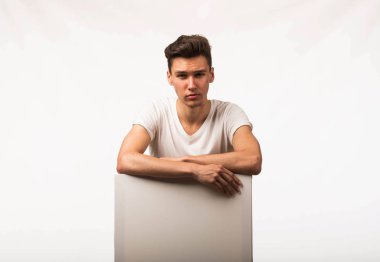 Sunu gösterilen, afiş üzerinde işaret eden genç seksi adam.