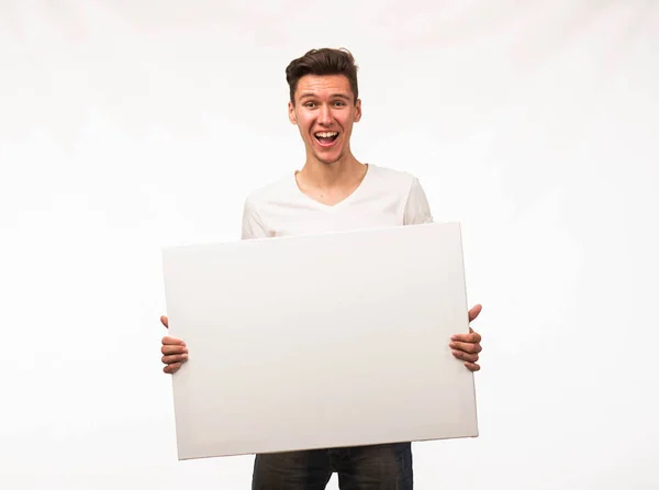 Jovem homem alegre mostrando apresentação, apontando no cartaz . — Fotografia de Stock