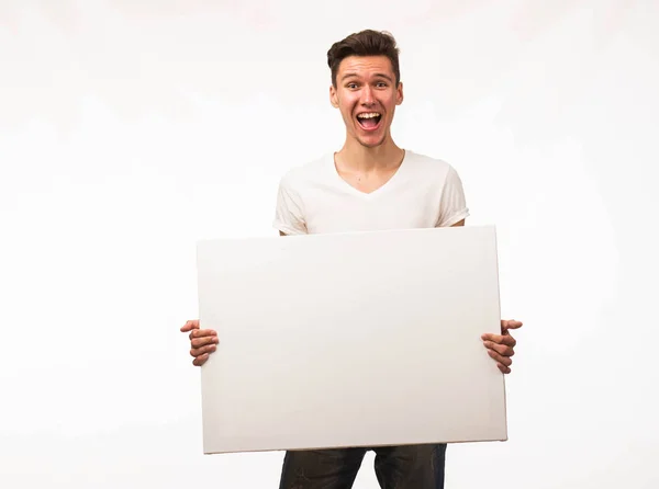 Jovem homem alegre mostrando apresentação, apontando no cartaz . — Fotografia de Stock