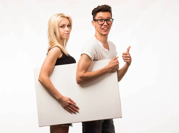 Молода щаслива пара показує презентацію, що вказує плакат . — стокове фото