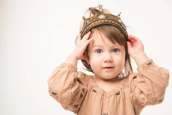 Aranyos kislány, bézs ruha arany korona elszigetelt fehér background. — Stock Fotó
