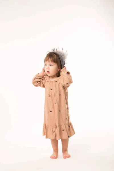 Menina bonito no vestido bege em um chapéu cinza isolado no fundo branco . — Fotografia de Stock