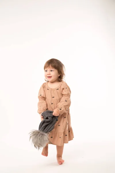 Menina bonito no vestido bege em um chapéu cinza isolado no fundo branco . — Fotografia de Stock