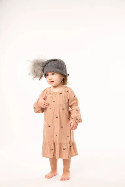 Menina bonito no vestido bege em um chapéu cinza isolado no fundo branco . — Fotografia de Stock