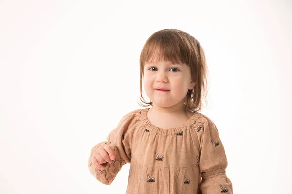 Menina bonito em vestido bege isolado no fundo branco . — Fotografia de Stock