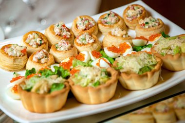 Salata havyarlı tartlar ve tabakta yumurtalar