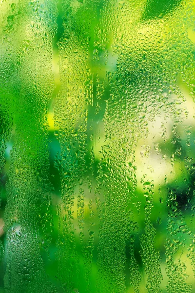 緑の背景にガラスに雨の滴 — ストック写真