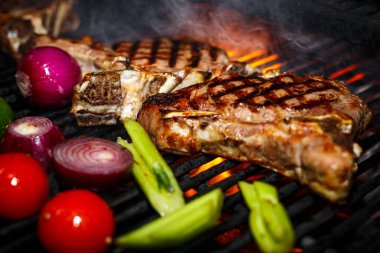 Biftek ateşte sebzeyle pişiriliyor.