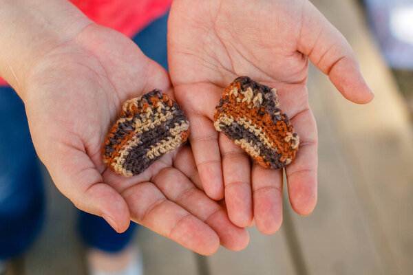 Вязаные носки для недоношенных детей в руках
