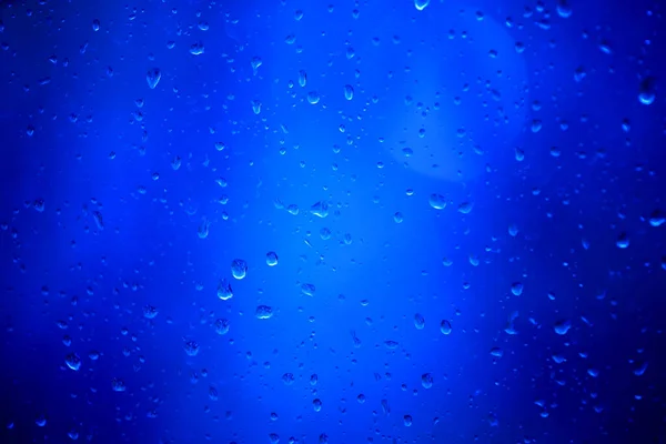 青い背景のガラスに雨の滴 — ストック写真