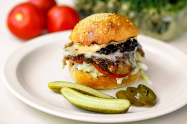 Spatulalı hamburger bifteği, soğanlı mozzarella ve salatalık ve jalapeno soslu Amerikan sosu.