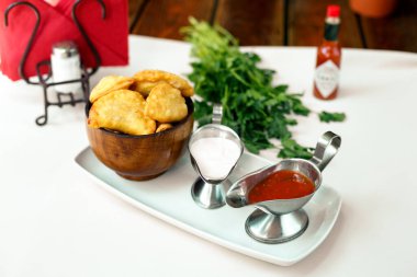 Tahta bir yüzeyde yeşillik ve çuvallı hamur işi.