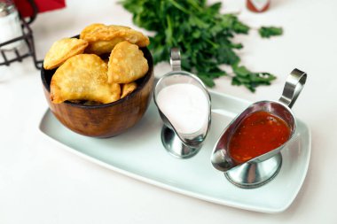 Tahta bir yüzeyde yeşillik ve çuvallı hamur işi.