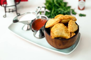 Tahta bir yüzeyde yeşillik ve çuvallı hamur işi.