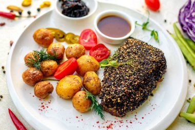 Biberli biftek ve fırında patates. Soğan turşusu ve sebze sosu.