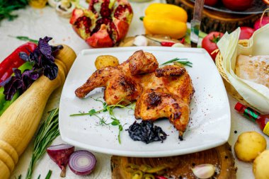 Kızarmış tavuk, soğan ve acı biberle süslenmiş bir masada.