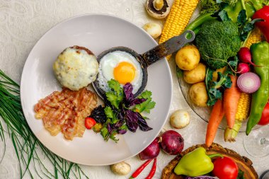 Kahvaltı, kızartma tavasında yumurta, domuz pastırması ve peynirli patates püresi.