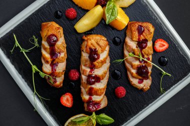 Siyah tabakta tütsülenmiş tavuk.