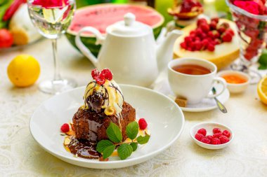 Dondurma ve meyveli çikolatalı kek servis masasında.