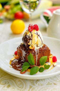 Dondurma ve meyveli çikolatalı kek servis masasında.