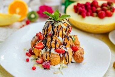 Krekembush, üzerinde çikolata ve fındık olan zarif bir Fransız profiterollü kek.