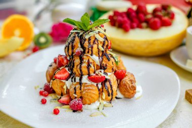 Krekembush, üzerinde çikolata ve fındık olan zarif bir Fransız profiterollü kek.