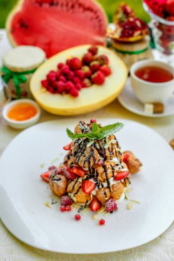 Krekembush, üzerinde çikolata ve fındık olan zarif bir Fransız profiterollü kek.