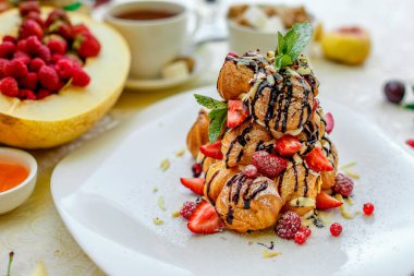 Krekembush, üzerinde çikolata ve fındık olan zarif bir Fransız profiterollü kek.