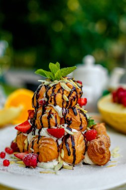 Krekembush, üzerinde çikolata ve fındık olan zarif bir Fransız profiterollü kek.