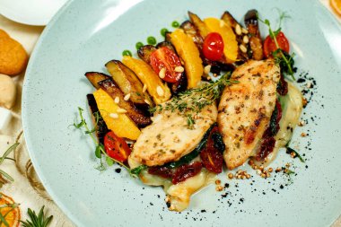 Tavuk göğsü, patates püresi, ızgara sebze ve masada servis edilen malzemeler.