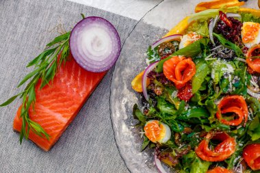 Sebzeli taze salata, yeşillik ve masada servis edilen havyarlı kırmızı balık, sağlıklı yiyecekler.