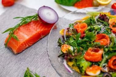 Sebzeli taze salata, yeşillik ve masada servis edilen havyarlı kırmızı balık, sağlıklı yiyecekler.