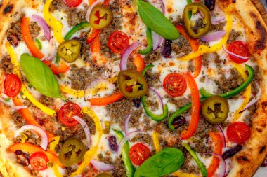 Peynir ve sebzelerle servis edilen lezzetli İtalyan pizzası.