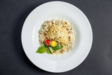 Mantarlı ve peynirli makarna, krema soslu bıldırcın yumurtası ve domates, izole edilmiş.